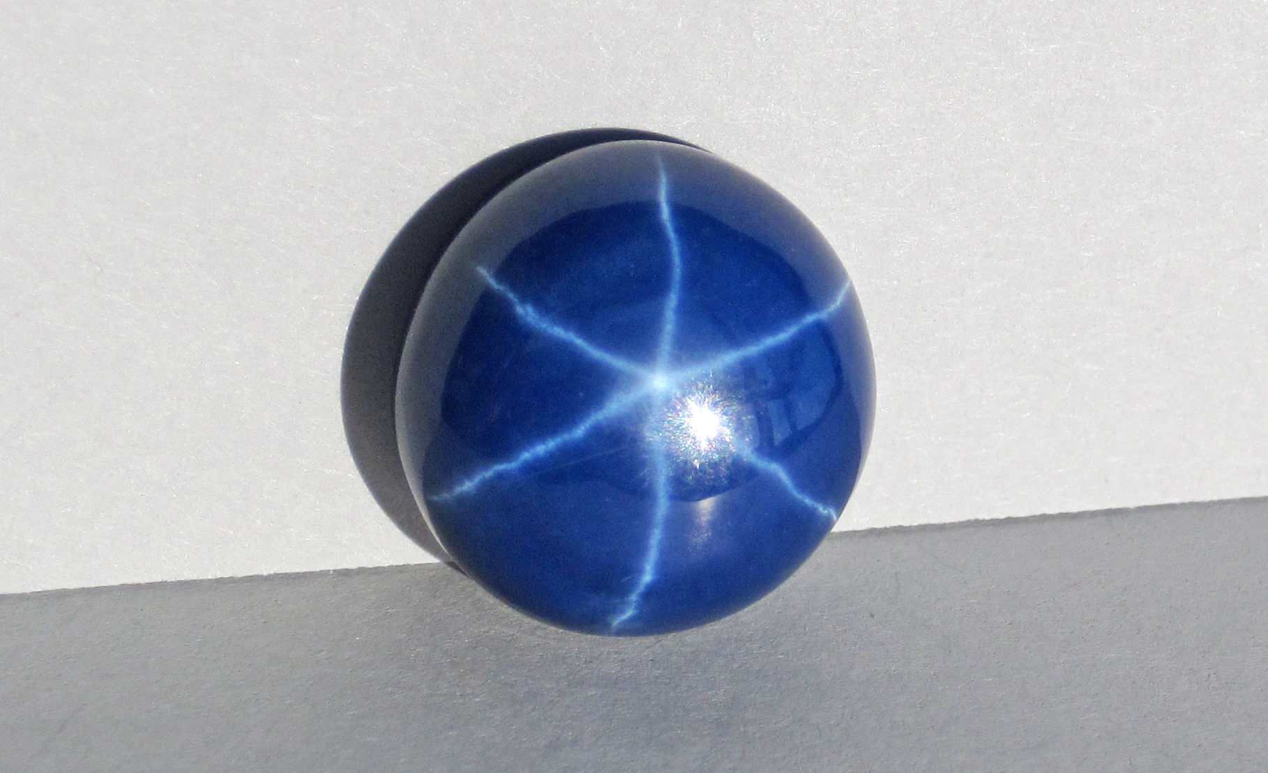 Cabochon de saphir étoilé bleu montrant un astérisme à six rayons